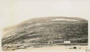Image of Building and tent against rocky bluff